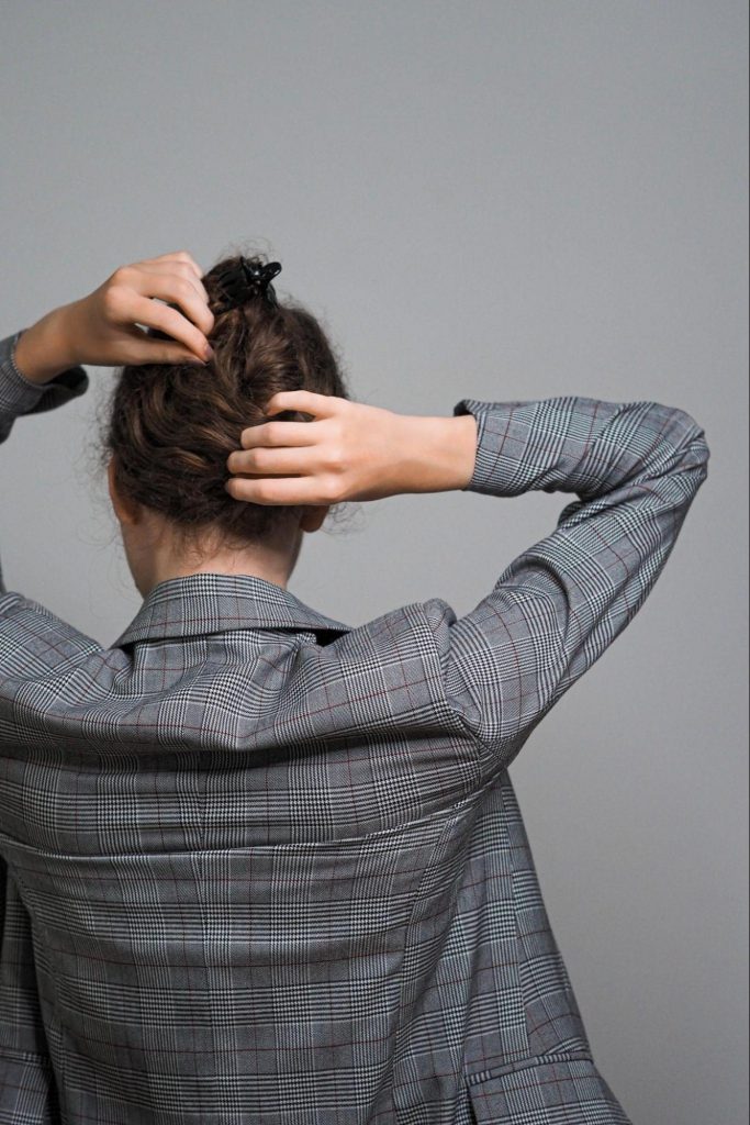 Woman in grey suit fixing hair